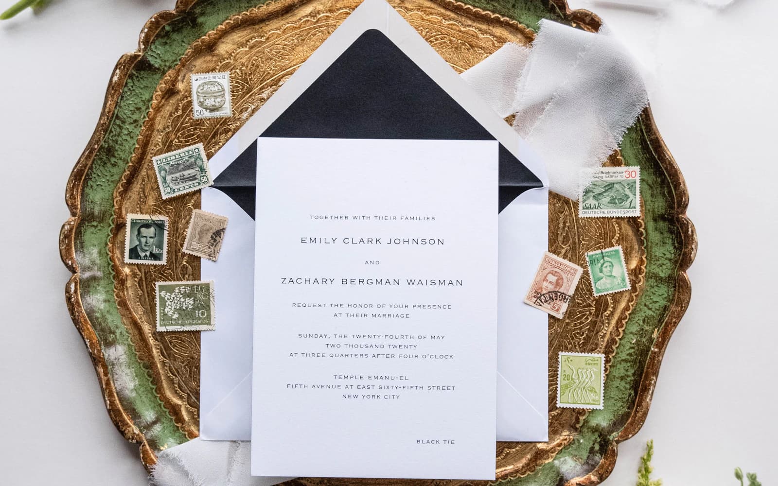 Wedding stationery and envelopes arranged with white flowers on a tray