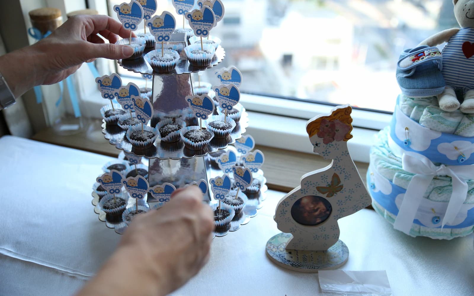 Cupcakes on a tiered stand with baby shower decorations