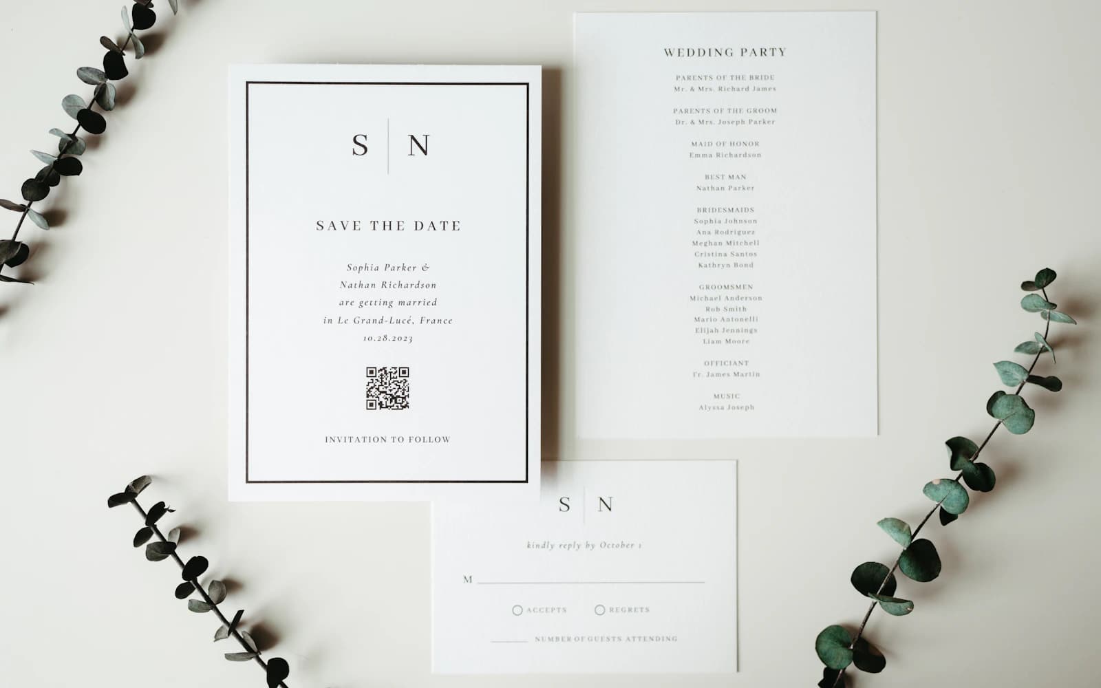 Wedding invitations and stationery arranged with greenery